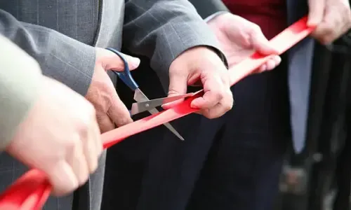 Stock image of hands cutting a ribbon